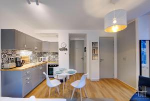 eine Küche mit einem Tisch und weißen Stühlen im Zimmer in der Unterkunft Le Lagon / 100m Gare in Tours