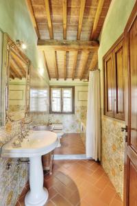 y baño con 3 lavabos, ducha y bañera. en Villa Antica Sosta Renai, en Castelfiorentino