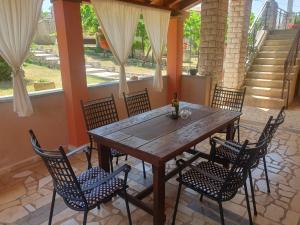 a wooden table and chairs on a patio at Apartman Sara in Pula