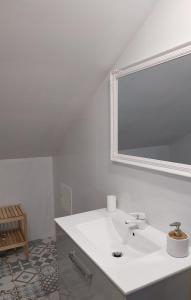 uma casa de banho branca com um lavatório e um espelho em EsposendeGuesthouse em Esposende