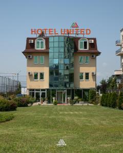 a hotel building with a sign on top of it at Hotel United PR in Pristina