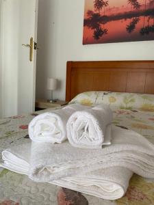 una pila de toallas sentadas en una cama en apartamento turístico CUATRO CAMINOS, en San Vicente de Alcántara