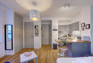 a kitchen and living room with a table and a counter at Le Fidji / 100m Gare in Tours +8 photos