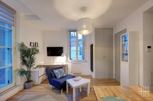 a living room with a blue chair and a table at Le Fidji / 100m Gare in Tours