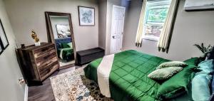 a bedroom with a green bed and a mirror at Cozy Nashville Duplex Unit B in Nashville