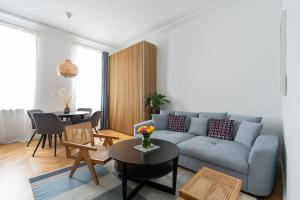 een woonkamer met een blauwe bank en een tafel bij HM • Fancy 1BR Near Schönbrunn in Wenen