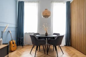 una sala da pranzo con tavolo, sedie e chitarra di HM • Fancy 1BR Near Schönbrunn a Vienna