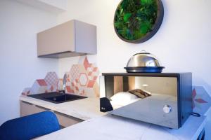 a kitchen with a counter with a sink and a mirror at Arrow Hôtel in Hégenheim