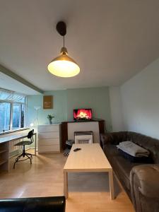 een woonkamer met een bank en een tafel bij Whitechapel Rooms R3 in Londen