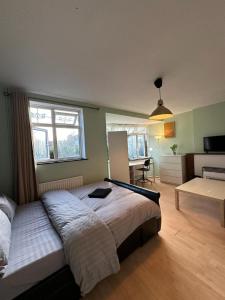 een slaapkamer met een groot bed en een bureau bij Whitechapel Rooms R3 in Londen