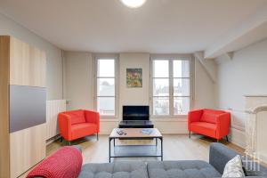 a living room with a couch and two red chairs at Le Jacobin - Saint Gatien- Bibliothèque in Tours