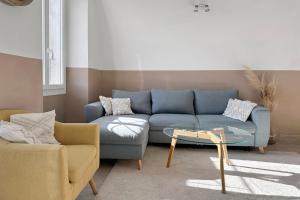 a living room with a blue couch and a table at Les Terrasses du Château I Electio in Lauris