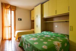 a bedroom with a green bed with flowers on it at CONDOMINIO LA QUERCIA in Bibione