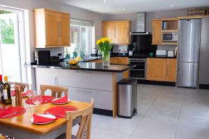 Bryn-y-Mor Apartment Mwnt في Tremain: مطبخ مع طاولة عليها لوحات حمراء