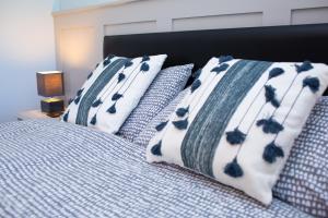 Bryn-y-Mor Apartment Mwnt في Tremain: سرير به شراشف ووسائد زرقاء وبيضاء