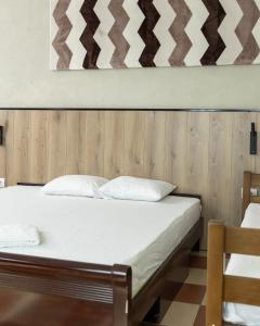 Hotel United PR في بريشتيني: سرير بشرشف ووسائد بيضاء في الغرفة