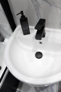 a clock and a remote control sitting on top of a toilet at Templar large garden flat in London +12 photos