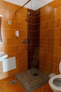 a bathroom with a shower with a toilet at Hotel United PR in Pristina