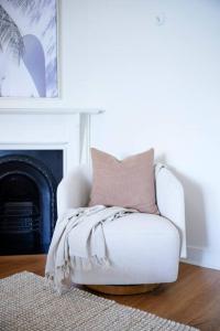 悉尼Waterfront - Designer Curated @ The Rocks Sydney的客厅配有带枕头的白色椅子