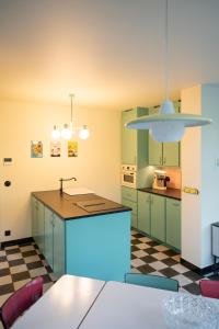 cocina con armarios verdes y suelo a cuadros en Huis Octaaf, en Heuvelland