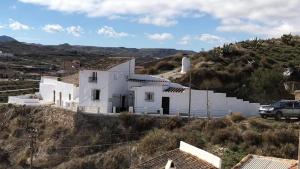 una casa blanca al lado de una colina en The Crystal Cave, en Zújar