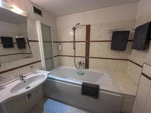 All-in rooms في فيلنيوس: حمام مع حوض استحمام ومغسلة