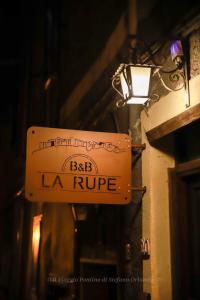 a sign for a bar la rouge hanging on a building at La Rupe Bed and Breakfast in Norma