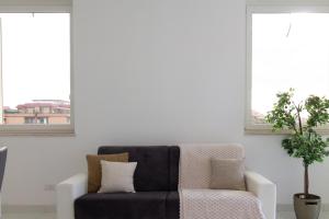 una sala de estar con un sofá negro y una planta en Sky Suite Green Pomezia, en Pomezia