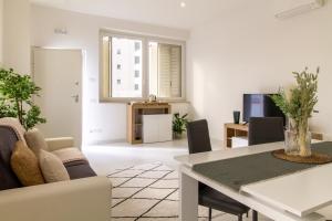 una sala de estar blanca con mesa y sillas en Sky Suite Green Pomezia, en Pomezia
