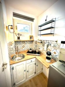 una piccola cucina con lavandino e finestra di Nido Alpino Sestriere a Sestriere