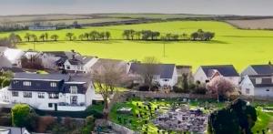 an aerial view of a suburb with houses and an elephant in the background at Orchard Lodge -Coastal Retreat, new build, village views, private garden and terrace in Saint Brides Major