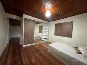 1 dormitorio con cama y techo de madera en Apt Amarração, en Luís Correia
