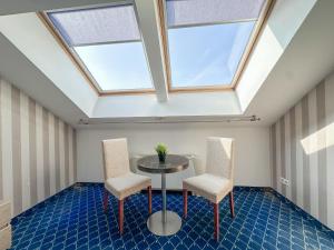a skylight in a room with a table and two chairs at All-in rooms in Vilnius
