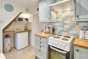 a kitchen with a white stove top oven next to a counter at Host & Stay - Claire's Cottage in Kent