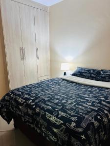 een slaapkamer met een bed met een blauwe en witte deken bij Tranquil Room in Apartment in Lusaka