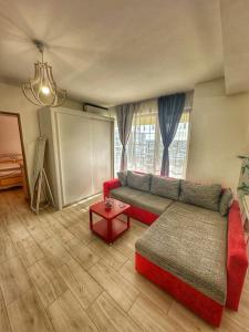 sala de estar con sofá rojo y mesa en Fancy Apartament Promenada Mall en Craiova