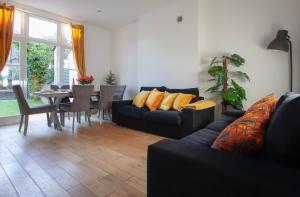 a living room with a couch and a dining room at Templar large garden flat in London