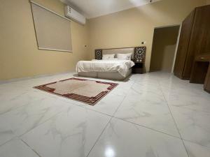 a bedroom with a bed and a tiled floor at مسكن الجنان للوحدات السكنية in Al Madinah