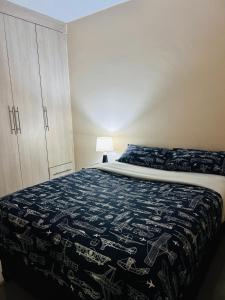 a bedroom with a bed with a blue blanket and a cabinet at Tranquil Room in Apartment in Lusaka