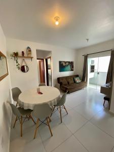 ein Esszimmer und ein Wohnzimmer mit einem Tisch und Stühlen in der Unterkunft Residencial Diva in Florianópolis