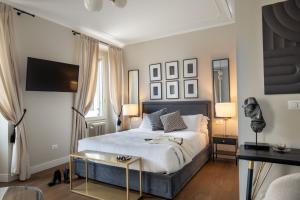 una camera con un letto con un tavolo e due lampade di Daplace - Corso Monforte Suites a Milano