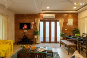 a living room with a brick wall at EKO STAY - Solace Villa I Charming Villa close to Candolim Beach in Marmagao