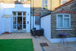 a house with a white door and a patio at Templar Apartment in London