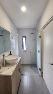 a white bathroom with a sink and a shower at Cozy room in three floor apartment in Mexico City