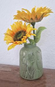 a green vase with yellow flowers in it at The Penthouse NY Loft Apartment in Barmouth