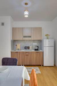 a kitchen with a table and a white refrigerator at City Plus 285/8 in Almaty