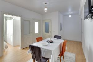 a white dining room with a white table and chairs at City Plus 285/8 in Almaty