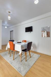 a white dining room with a table and chairs at City Plus 285/8 in Almaty