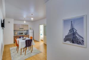 a kitchen with a table and a picture of the eiffel tower at City Plus 285/8 in Almaty