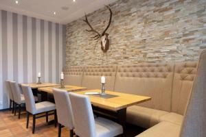 une salle à manger avec des tables et des chaises et un mur en briques dans l'établissement Hotel Wildpferd Dülmen, à Dülmen